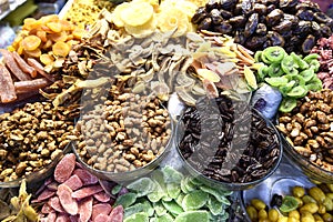 Large amount of different dried fruits apples, oranges, lemons, raisins, kiwi, nuts pistachio, hazelnut, peanut.