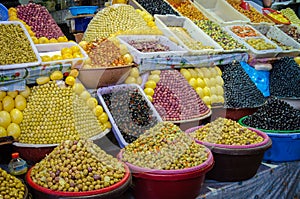 Large amounts of pyramidically stacked olives for sale on market or soukh of Marrakesh, Morocco