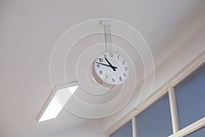 large analog clock hanging from ceiling