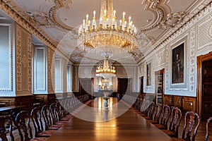 Large antique wooden table under a crystal chandelier in a historic hall