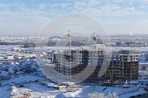 Large apartment buildings construction in new district among rural houses, urbanisation in action. Winter season. photo