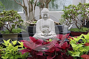 Large Asian Statue Sitting In An Indoor Zen Garden At The Botanical Gardens In Buffalo NY.