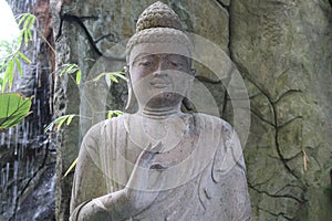 Large Asian Statue Sitting In An Indoor Zen Garden At The Botanical Gardens In Buffalo NY.