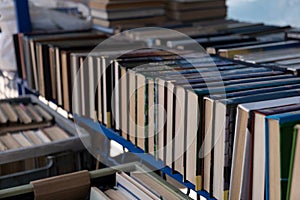 Large assortment of old books at the flea market. Yellowed volumes of poetry outdoors clearance sale of the home library.