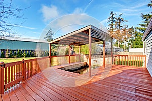 Large back yard with grass, covered deck and grass.