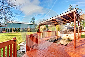 Large back yard with grass, covered deck and grass.