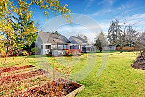 Large back yard with grass, covered deck and grass.