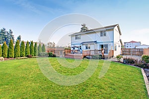 Large back yard with lots of grass and deck.