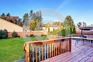 Large back yard with lots of grass and deck. photo