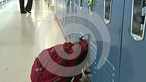 A large backpack sitting outside a locker