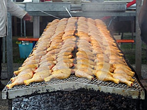 Large barbecue of grilled chicken thighs on charcoal