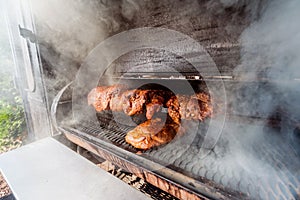 Large barbecue smoker grill at the park. Meat prepared in barbecue smoker.