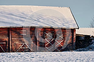 the large barn is red and has snow on it's roof