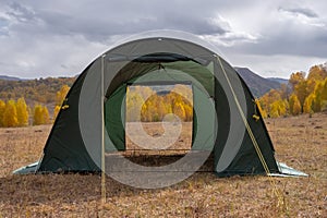 Large basecamp tents on colorful mountains background