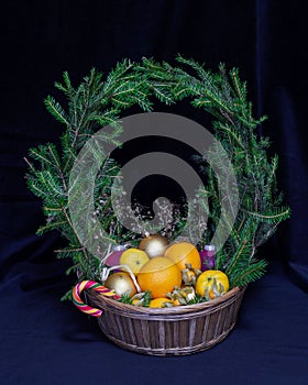 A large basket of fruit and Christmas balls. Crowned wreath of s