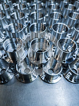 A large batch of shiny metal cnc aerospace parts - close-up with selective focus for industrial manufacturing background