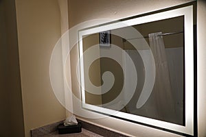 A large bathroom mirror with lights on the edges