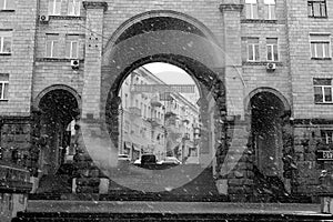 A large beautiful arch between two houses and a wide staircase on the approach to it.