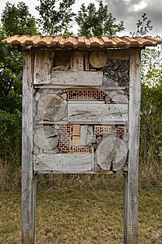 Large and beautiful insect hotel in the corridor near a creek with a tiled roof as protection against rain