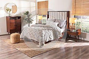 the large bedroom has wooden floors and walls and is furnished with a beige bed spread