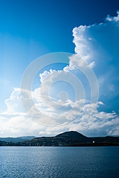 Large billowing clouds above coastal village