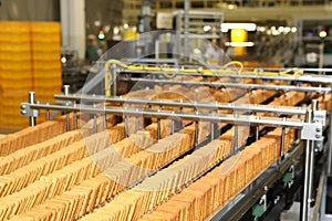 Large biscuit factory. A line of biscuits in a large factory. Packing crackers on the machine. Innovative production.