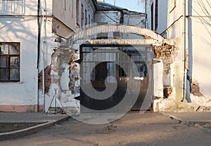 Large black metal gate in the arch of the old brick house