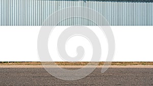 Large blank billboard on road with corrugated metal wall in background ready for graphic display or advertising. Perfect