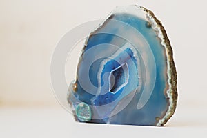 Large blue crystal of agate cross section isolated on white background. Natural translucent surface of agate crystal, blue