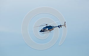 A large, blue helicopter is flying