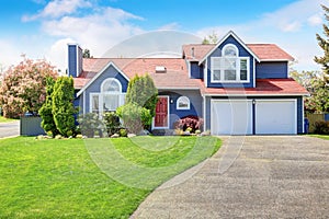 Large blue house with white trim and a nice lawn.