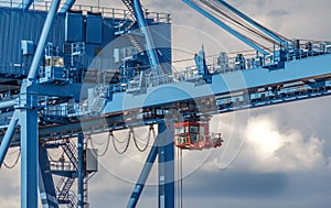 Large, blue industrial crane against cloudy sky