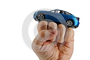 Large blue SUV car model placed on raised fist of adult man, white background.