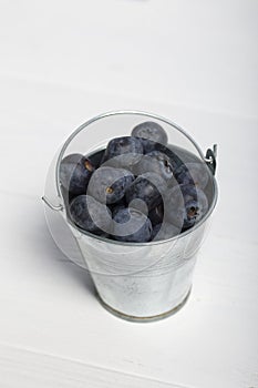 Large blueberries in a decorative bucket. International day without diets. On a white background. Close-up