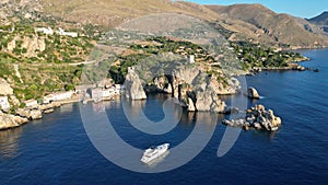 a large boat is sailing near the shore and hills of small town