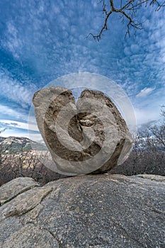 Large boulder of granite rock surounded by trees at Silla de Felipe II Phillip II chair in Guadarrama Mountains, Madrid, Spain photo