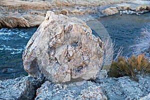 Large Boulder Sitting Along the Bank of a Stream 