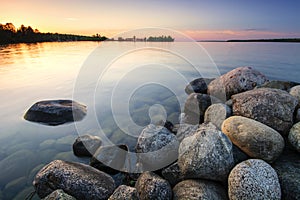 Large boulders on lake shore at sunset. Minnesota, USA photo