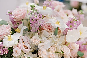 A large bouquet of fresh colors of light and pastel shades on the groom and bride `s table