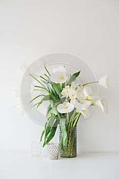 Large bouquet of white spring flowers in a vase, daffodils, tuli