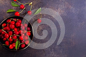 Large bowl of bright red cherries on dark background