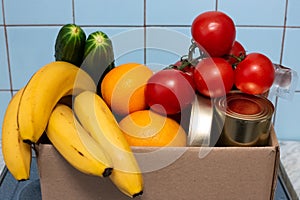 A large box with food and vegetables is in the kitchen, donations for those in need during self-isolation