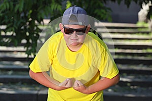 a large boy in a yellow T-shirt tenses his muscle. the concept of body positivity photo