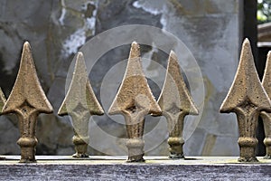 Large brass spear finials on top of iron gate