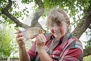 Large bream in women`s hands. Girl on a fishing trip