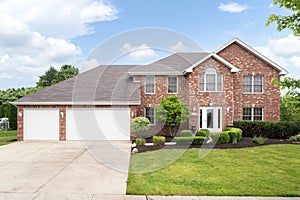 A large brick home with a three car garage.