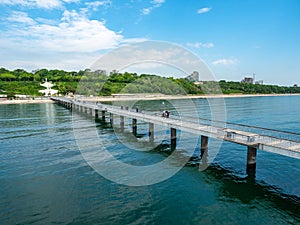 A large bridge with a pier and jumping and walking people in Burgas, Bulgaria