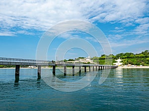 A large bridge with a pier and jumping and walking people in Burgas, Bulgaria