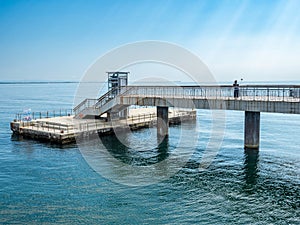 A large bridge with a pier and jumping and walking people in Burgas, Bulgaria