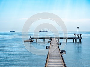 A large bridge with a pier and jumping and walking people in Burgas, Bulgaria